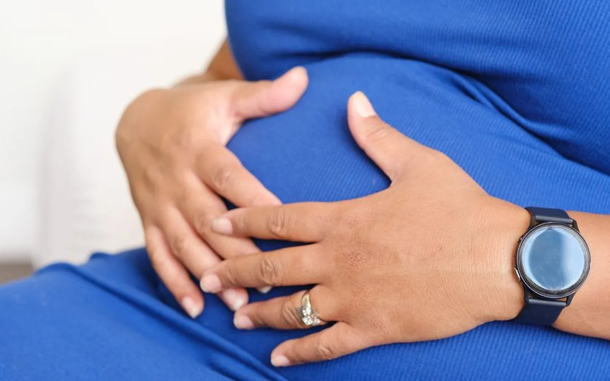 An expecting mother resting her hands on her belly