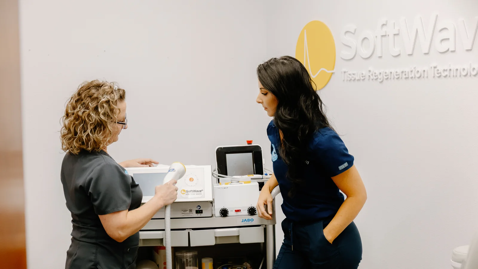Circle Chiropractic team member preparing the SoftWave tissue regeneration therapy device